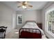 Cozy bedroom with large windows, ceiling fan, a red metal bed frame, and neutral carpeting at 7932 Twin Pines Way, Fuquay Varina, NC 27526