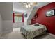 Bedroom features a patterned duvet, vibrant red accent wall, ceiling fan, and natural lighting at 7932 Twin Pines Way, Fuquay Varina, NC 27526
