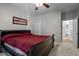 Bedroom featuring a wooden sleigh bed with a red comforter, neutral carpeting, and a ceiling fan at 7932 Twin Pines Way, Fuquay Varina, NC 27526