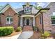 Inviting brick home featuring an elegant entrance with brick steps, pillars and landscaped surroundings at 7932 Twin Pines Way, Fuquay Varina, NC 27526