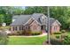 An elevated view of a stunning brick home nestled among lush greenery at 7932 Twin Pines Way, Fuquay Varina, NC 27526