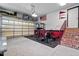 Finished garage space featuring epoxy floors, gym equipment, and brick stairs with red railings at 7932 Twin Pines Way, Fuquay Varina, NC 27526