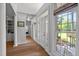Hallway with hardwood floors and natural light from windows, leading to bedrooms and backyard at 7932 Twin Pines Way, Fuquay Varina, NC 27526