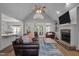 Spacious living room with vaulted ceiling, stone fireplace, and hardwood floors leads to an outdoor porch at 7932 Twin Pines Way, Fuquay Varina, NC 27526