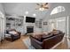 Bright living room boasts a vaulted ceiling, stone fireplace with built-in shelves, and wood floors at 7932 Twin Pines Way, Fuquay Varina, NC 27526