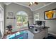 Bright home office featuring hardwood floors, arched window with backyard view, and ceiling fan at 7932 Twin Pines Way, Fuquay Varina, NC 27526