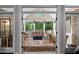 Inviting screened porch featuring a colorful rug, comfortable seating, and serene wooded views at 7932 Twin Pines Way, Fuquay Varina, NC 27526