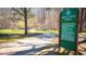 Community trail sign and paved path in a leafy neighborhood area at 800 Pritchard Avenue Ext # H3, Chapel Hill, NC 27516