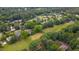 Aerial view of a wooded community featuring a grassy area, pond, and multiple residences at 8042 Hogan Dr, Wake Forest, NC 27587