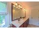 Bright bathroom featuring double sinks, a large mirror, and a window for natural light at 8042 Hogan Dr, Wake Forest, NC 27587