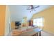 Bright bonus room with a ceiling fan, large couch, guitar, TV, and natural light from the windows at 8042 Hogan Dr, Wake Forest, NC 27587