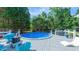 Backyard with an above ground pool, blue patio furniture, grill, and wooden deck at 8042 Hogan Dr, Wake Forest, NC 27587