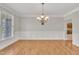 Light-filled dining room with hardwood floors, wainscoting, and elegant chandelier at 805 Alden Bridge Dr, Cary, NC 27519
