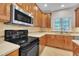 Modern kitchen featuring stainless steel appliances, wooden cabinetry and tiled backsplash at 805 Alden Bridge Dr, Cary, NC 27519