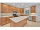 Spacious kitchen with wooden cabinets, stainless steel appliances, large central island and a tile floor at 805 Alden Bridge Dr, Cary, NC 27519