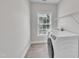 Well-lit laundry room featuring modern washer and dryer and shelving for storage at 805 Alden Bridge Dr, Cary, NC 27519