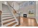 Open-concept living room with fireplace, hardwood floors, staircase and large windows for natural light at 805 Alden Bridge Dr, Cary, NC 27519