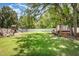 Sprawling backyard with lush green lawn, mature trees, and a playset, creating a serene outdoor space at 816 Trumpet Vine Ct, Wendell, NC 27591