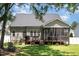 Exterior shot showing the back of the house with a screened porch and a well-maintained lawn at 816 Trumpet Vine Ct, Wendell, NC 27591