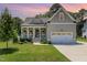 Charming home boasts a well-manicured lawn, a welcoming front porch, and an attached two-car garage at 816 Trumpet Vine Ct, Wendell, NC 27591