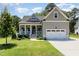 Charming home boasts a well-manicured lawn, a welcoming front porch, and an attached two-car garage at 816 Trumpet Vine Ct, Wendell, NC 27591