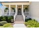 Inviting front porch featuring hanging plants, a cozy seating area, and a stylish welcome mat at 816 Trumpet Vine Ct, Wendell, NC 27591