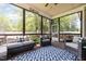 Screened porch with comfortable seating, a ceiling fan, and views of a lush backyard at 816 Trumpet Vine Ct, Wendell, NC 27591