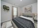 Bright bedroom with a plaid comforter, neutral walls, wall art, and indoor plants at 845 Ottawa Dr, Garner, NC 27529