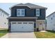 Two-story home with dark siding, a white garage door, and a small front yard at 845 Ottawa Dr, Garner, NC 27529