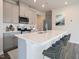 Modern kitchen with grey cabinets, stainless steel appliances, and quartz countertops, with island seating at 845 Ottawa Dr, Garner, NC 27529