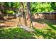 Backyard with a homemade wooden swing set surrounded by green grass and a wood privacy fence at 903 W Maynard Ave, Durham, NC 27704