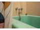 Retro bathroom bathtub featuring stainless steel fixtures and partial shower curtain, a unique vintage style at 903 W Maynard Ave, Durham, NC 27704