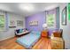 Charming bedroom with hardwood floors and a colorful purple accent wall, creating a vibrant and inviting space at 903 W Maynard Ave, Durham, NC 27704