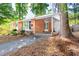 Mid-century modern home with a red brick exterior, car port, and mature shade trees in a quiet neighborhood at 903 W Maynard Ave, Durham, NC 27704