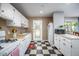 Functional kitchen featuring white cabinets and appliances, and a checkered floor extending to the doorway at 903 W Maynard Ave, Durham, NC 27704