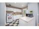 Cozy kitchen featuring white appliances, checkered flooring, and ample cabinet space for storage at 903 W Maynard Ave, Durham, NC 27704