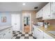 Bright kitchen with ample storage, view into a living room, and classic black and white checkerboard floor at 903 W Maynard Ave, Durham, NC 27704