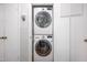 Efficient laundry room features stacked washer and dryer, and built-in shelving for storage solutions at 903 W Maynard Ave, Durham, NC 27704