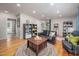Bright living room with black leather sofa, hardwood floors, and a colorful arcade game at 903 W Maynard Ave, Durham, NC 27704