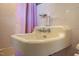 Close-up of a vintage bathroom sink with pink shower curtain in the background at 903 W Maynard Ave, Durham, NC 27704