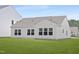 A light and airy back exterior with manicured lawn and many windows illuminating the interior at 94 Mable Court # 16, Lillington, NC 27546