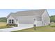 View of the home's exterior featuring a two-car garage, stone accents, and a well-maintained lawn at 94 Mable Court # 16, Lillington, NC 27546