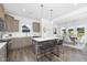 Modern kitchen with an island, stainless steel appliances, quartz countertops, and a view of the dining room at 94 Mable Court # 16, Lillington, NC 27546