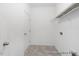 Bright laundry room with tiled floors, shelving, and a white door at 94 Mable Court # 16, Lillington, NC 27546
