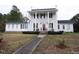 Charming two-story white home featuring a traditional front porch and manicured lawn at 100 Lager Ln, Garner, NC 27529