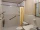 Bathroom featuring toilet, sink, shower, and vertical striped wallpaper at 1005 Driftwood Dr, Siler City, NC 27344