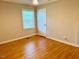 Neutral bedroom with hardwood floors, window, and white door at 1005 Driftwood Dr, Siler City, NC 27344