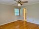 Bedroom with ceiling fan, window, wood floors, and door to bath at 1005 Driftwood Dr, Siler City, NC 27344