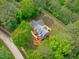 An aerial view of the property with lush landscaping, wooden deck, and surrounding mature trees at 1016 Luminary Ln, Willow Springs, NC 27592