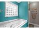 Stylish bathroom featuring a modern tub, shower and bright blue wall at 1016 Luminary Ln, Willow Springs, NC 27592